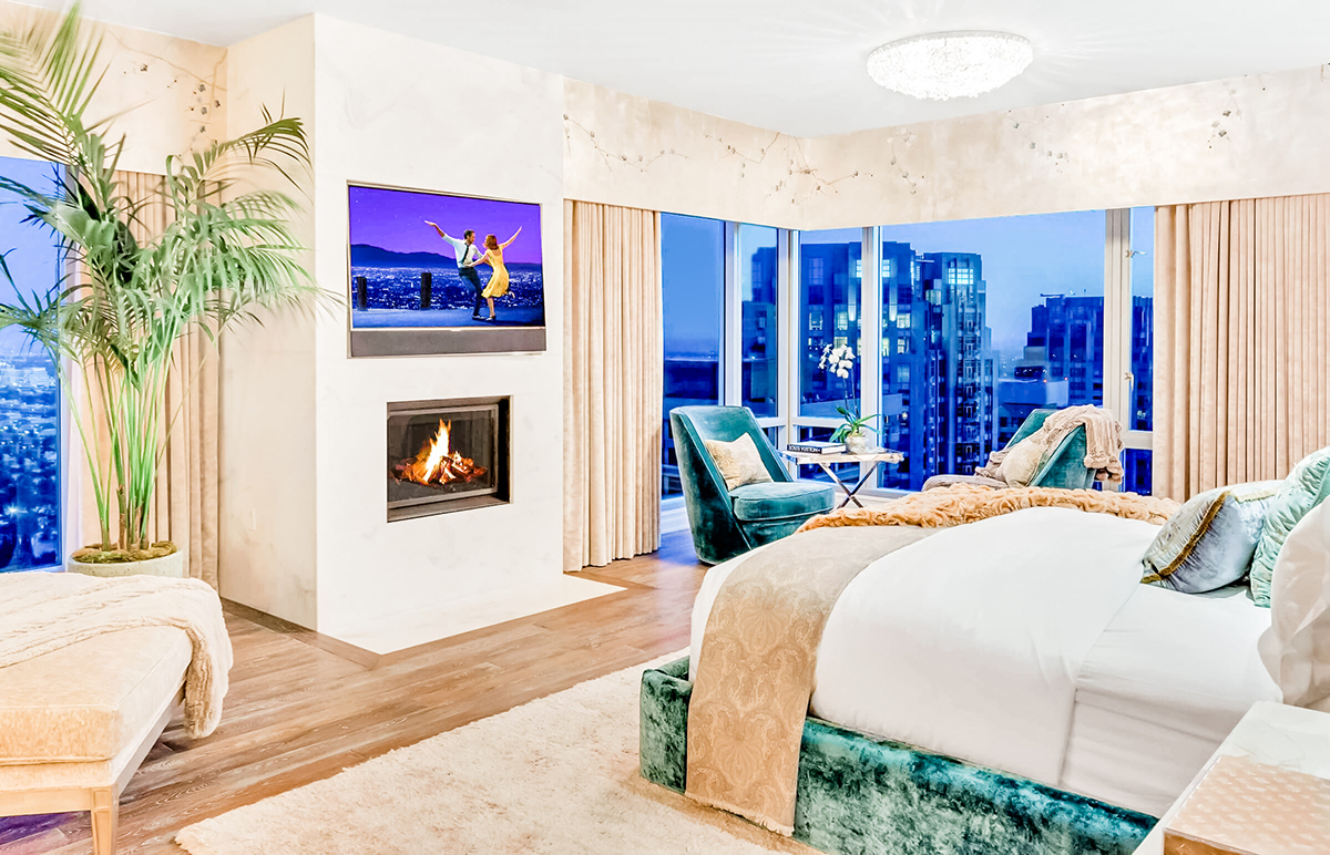 bedroom with tv mounted above fireplace